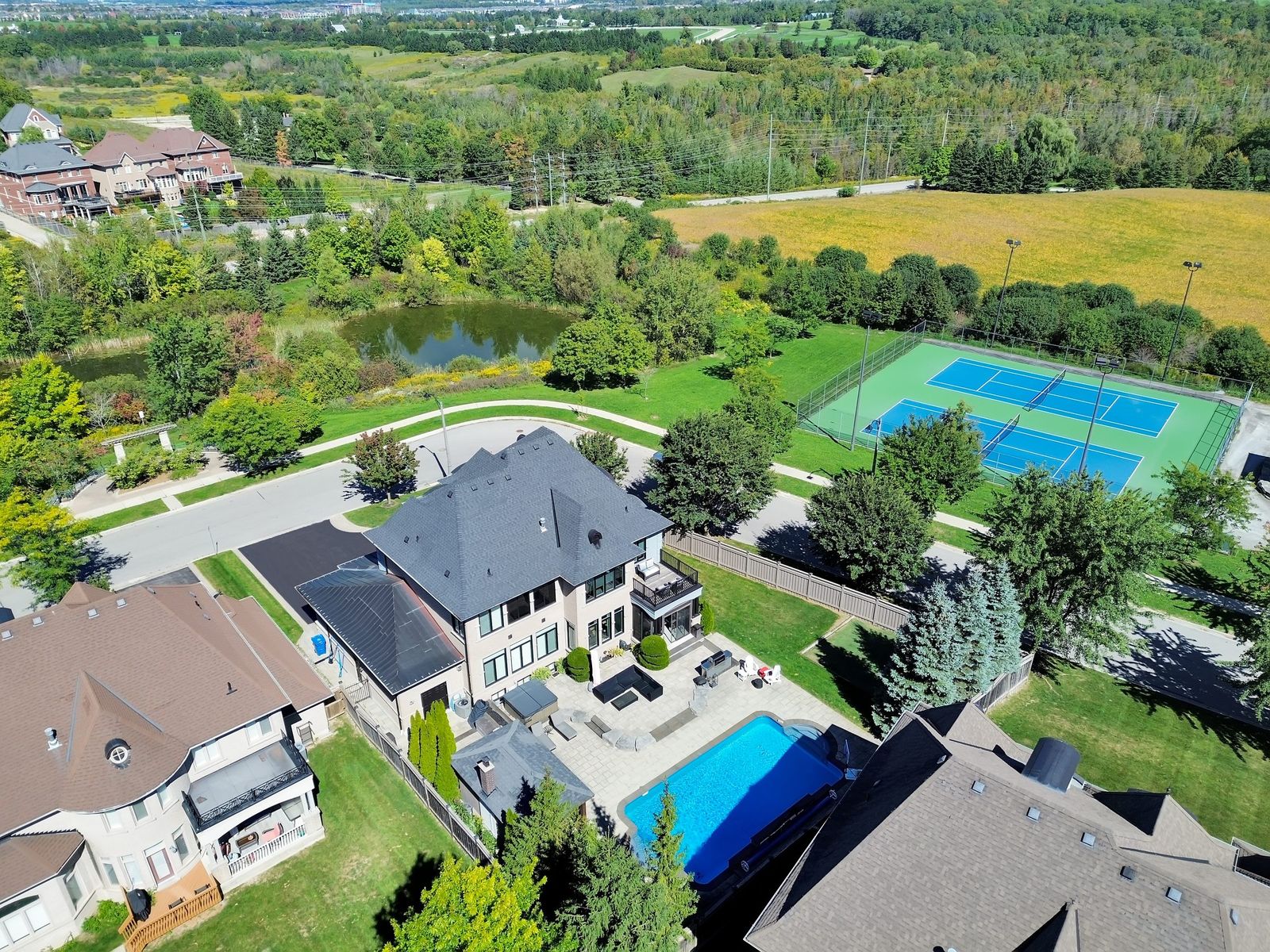 Aerial of an estate property with pool and tennis courts