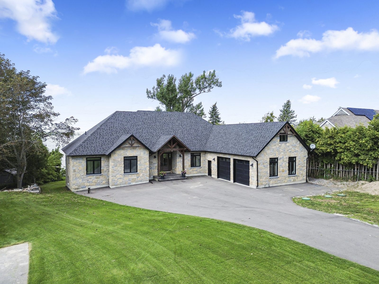 Stone bungalow exterior with manicured lawn, Simcoe County