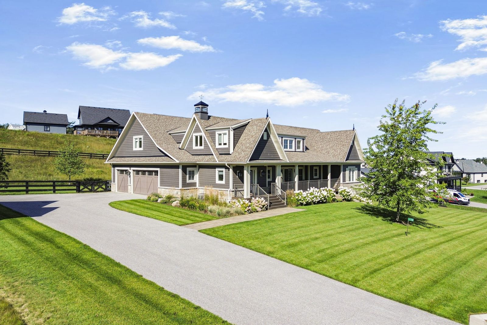 Country home exterior with wraparound porch and blue sky