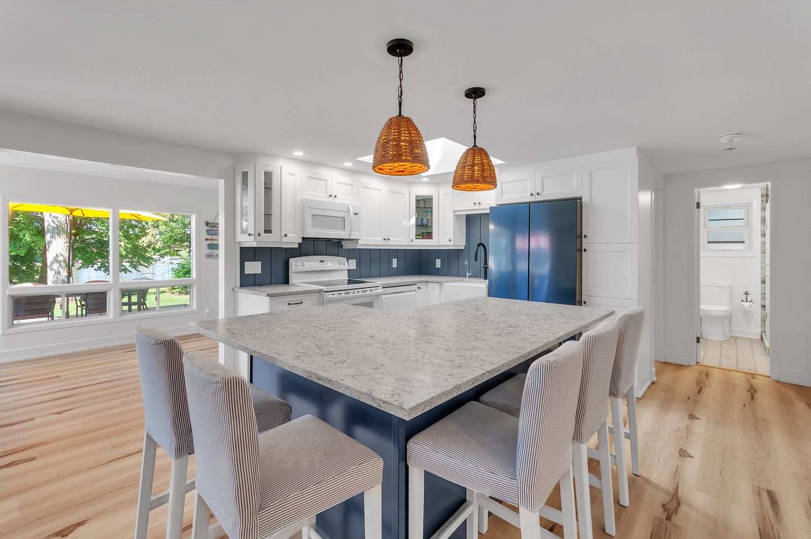 Dining area open to a white kitchen, natural light