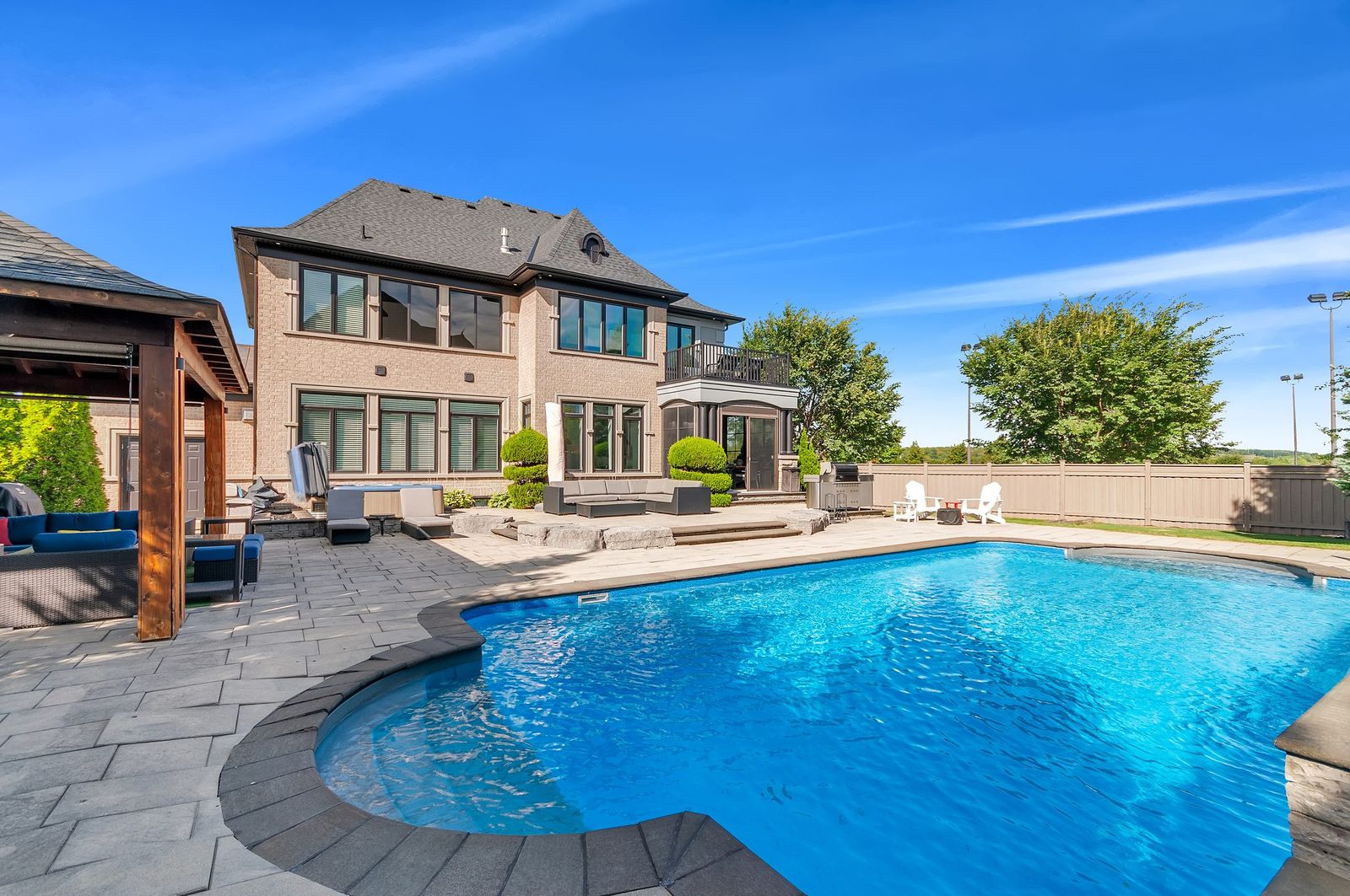 Backyard pool and patio with blue sky, estate exterior