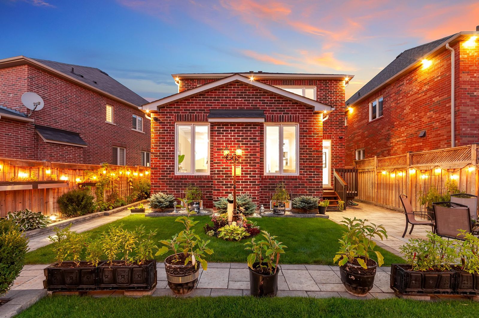 Rear exterior at twilight with planters and patio lighting