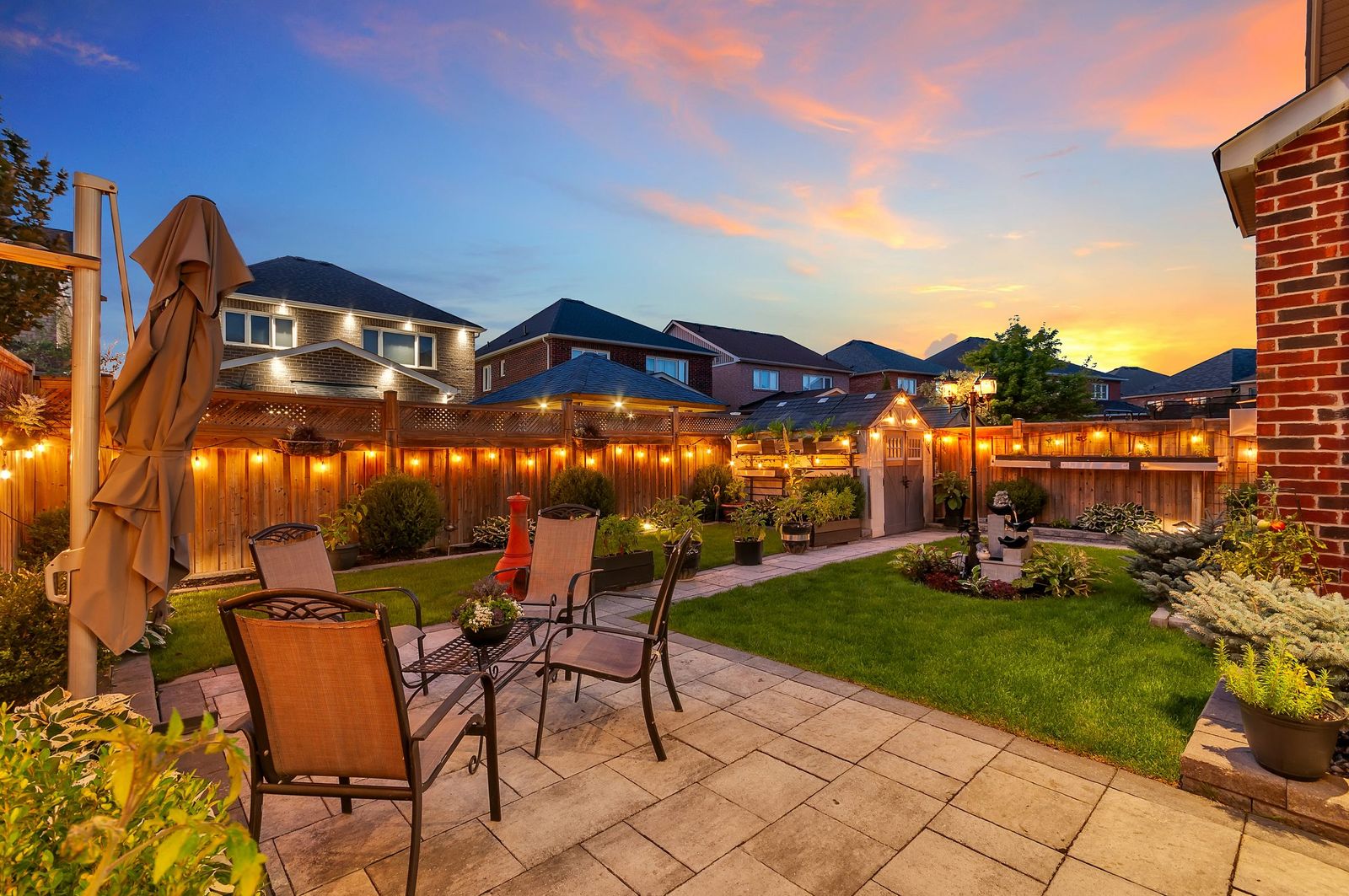 Backyard patio and dining set at dusk with string lights