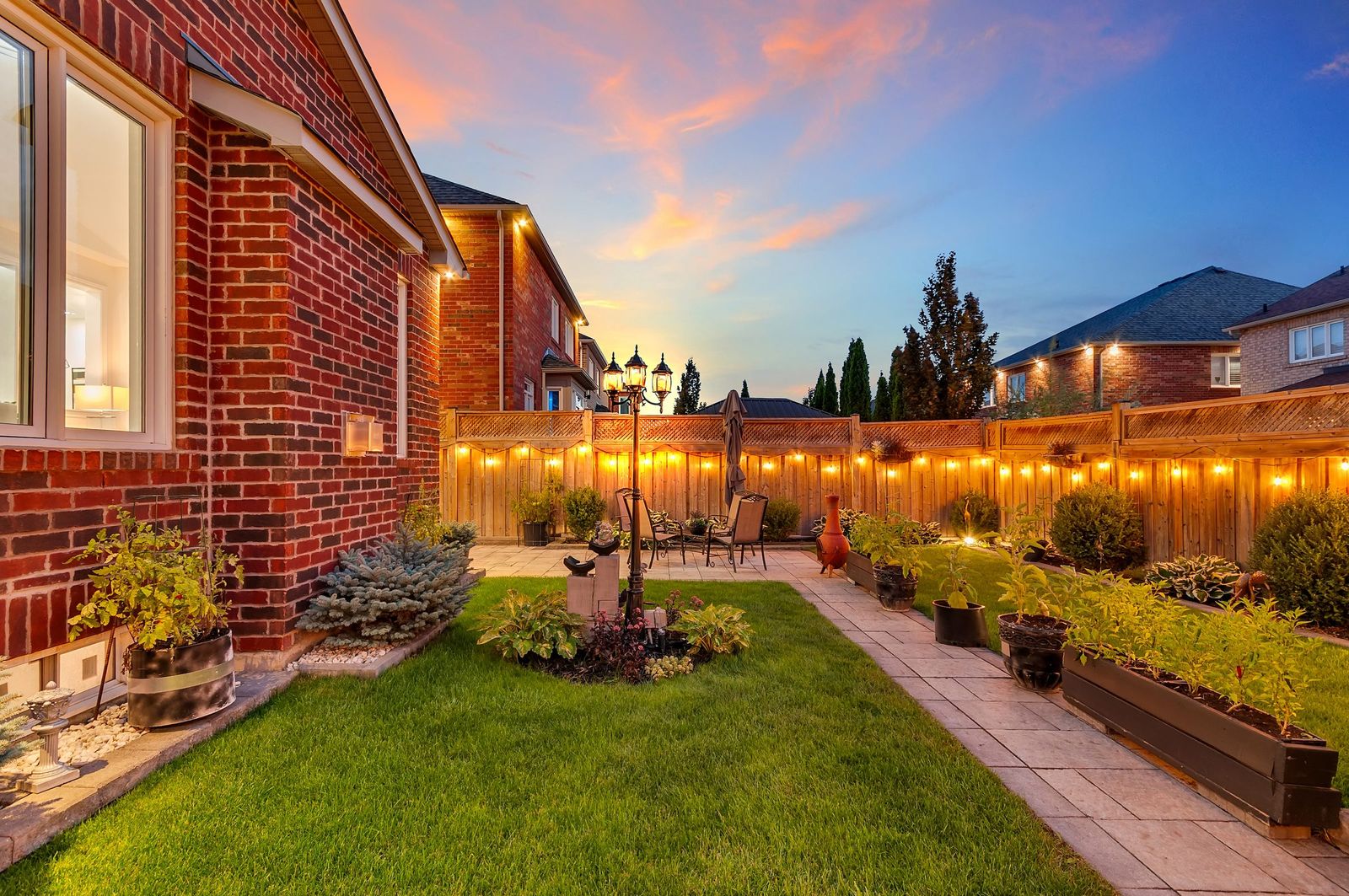 Side yard and garden at twilight with warm lighting